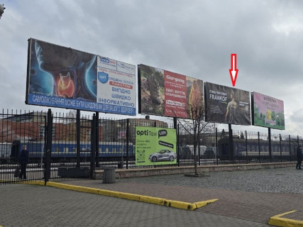 Білборд A у Івано-Франківську, 3x6  Привокзальна пл., 1, перед парканом, праворуч будівлі вокзалу, 2-й від автовокзалу, площина з боку міста Фото 1