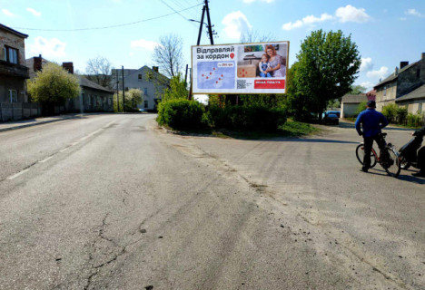 Билборд A в Рава-Русская (Рава-Русская), 6x3м.  м. Рава - Руська, вул. Львівська, Центр міста, ЗОШ, світлофор, з кордону на Україну, Міжнародна дорога М-09  Львів-Рава-Руська, максимальна пряма видимість, інтенсивний рух, + жовта вітрозахисна люмінесцентна рамка  фото 1