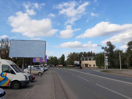 Билборд B в Кривом Роге 129-ї бригад.територ.оборони вул. (кол. Купріна), 15. ринок "Змичка", напрямок руху з Захисників України площа (кол. Визволення) до Кировоградського шосе. Зупинка громадського транспорту Змичка, Авіа коледж, магазини, кафе. Червона лінія руху транспорту. фото 1