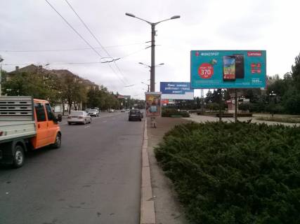 Билборд A в Кривом Роге пр. Металургів, парк, БК Металургів. Напрямок від 95-го кв. до Арселор Міталл Кривий Ріг. Червона лінія. Великий трафік руху транспорту та громадського транспорту. Вхід до станції ШТ. фото 1